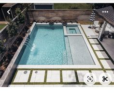 an aerial view of a swimming pool in a backyard with grass and white tiles on the ground