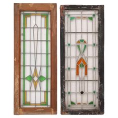 two stained glass windows with wooden frames and wood trimmings, one in green and the other in orange