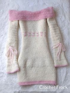 a crocheted sweater with pink trims on the shoulders and shoulder, sitting on a white surface