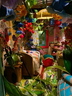 a room filled with lots of different types of flowers and plants hanging from the ceiling