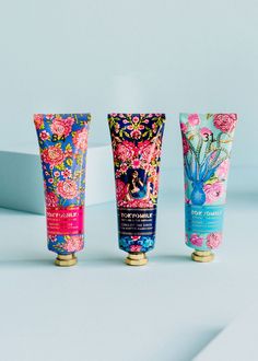 three different types of hand and body creams on a white surface with blue background