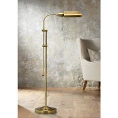 a gold floor lamp with a white chair in the background