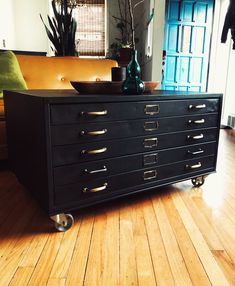 a black dresser sitting on top of a hard wood floor