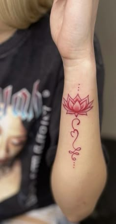 a woman's arm with a tattoo on it that has a pink flower and heart