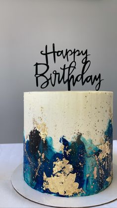 a blue and gold birthday cake with the words happy birthday on it's top