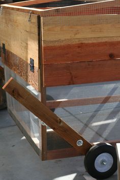 a wooden box with wheels attached to it