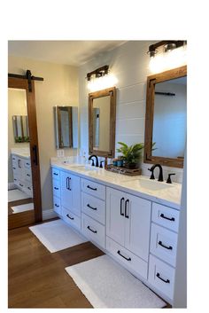 a bathroom with two sinks, mirrors and lights on the wall above them is shown