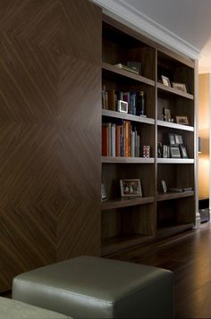 a book shelf with many books on it and a bench in front of the shelves