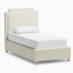 a bed with a white headboard and pillows on it's sides, in front of a white background