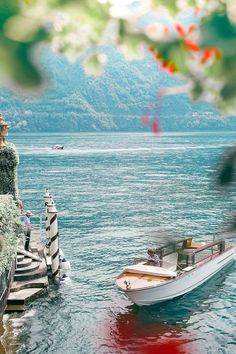 there is a boat that is in the water next to a pier and some trees