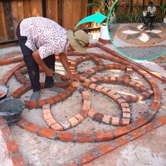 a woman is working on some bricks in the ground