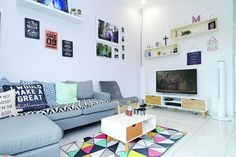 a living room filled with lots of furniture next to a flat screen tv mounted on a wall