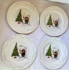 four white plates with christmas designs on them