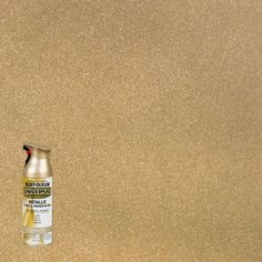 a bottle of spray paint sitting on top of a brown floor next to a wall