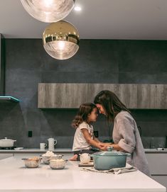 a mother and daughter cooking together in the kitchen