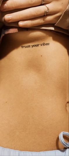 a woman's stomach with the words trust your vibes written on it