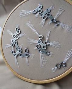 a close up of a embroidery on a piece of cloth with scissors in the middle