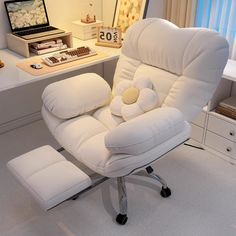 a white chair sitting in front of a desk with a laptop computer on top of it