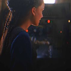 a woman with braids standing in front of a tv