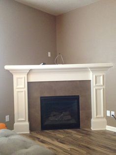 an empty living room with a fireplace in the middle and no one around it on the other side