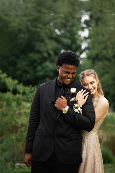 a man in a suit and woman in a gold dress posing for a photo together