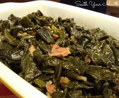 a white bowl filled with greens and meat