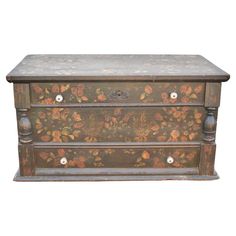 an old wooden chest with painted flowers on it's sides and two drawers in the middle