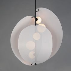 a white light hanging from a black metal pole with three lights on each one side