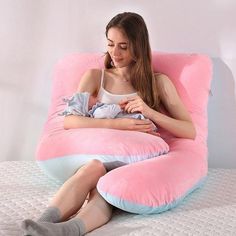 a woman sitting on a pink and blue pillow