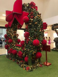 the christmas tree is decorated with red balls and bows