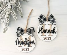 two personalized christmas ornaments hanging from a tree