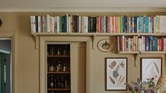 the bookshelves are filled with many different types of books and vases in front of them