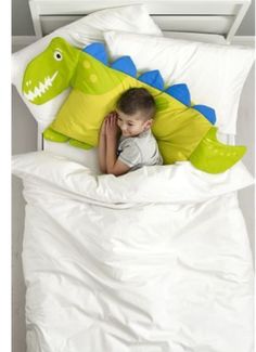 a young boy laying in bed under a green and blue pillow with an alligator on it