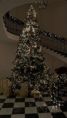 a large christmas tree in the middle of a checkered floor with lights on it