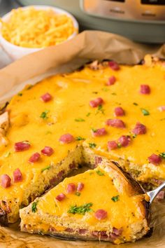 a cheesy casserole on a cutting board with a serving utensil