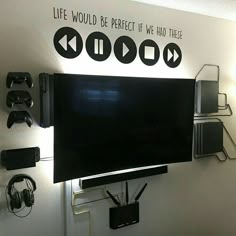 a flat screen tv mounted to the side of a wall with headphones on it