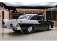 an old black and white car in a showroom