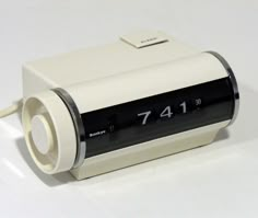 an alarm clock sitting on top of a white table