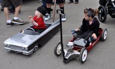 two small children are riding in an electric car