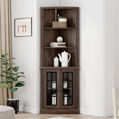 a wooden shelf with glass doors in a living room next to a chair and potted plant