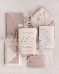 the wedding stationery is laid out on top of each other, including an envelope