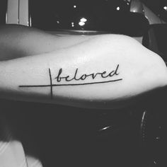 a woman's arm with the word beloved tattooed on her left shoulder and cross