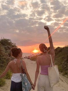 two women walking down a beach holding hands