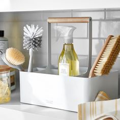 a bathroom counter with soap, toothbrushes and other cleaning products on it's shelf