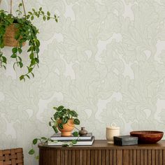 a table with some books and a potted plant on it next to a wall