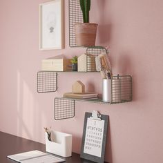 a desk with a calendar, pen holder and plant on the wall next to it