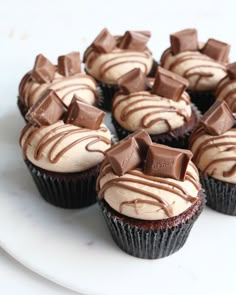 chocolate cupcakes with white frosting on a plate