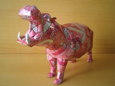 a pink origami rhinoceros on a wooden table