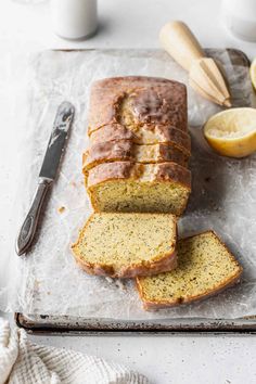 a loaf of lemon poppy seed bread on a cutting board next to sliced lemons