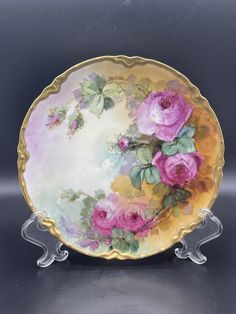 a decorative plate with pink roses on it